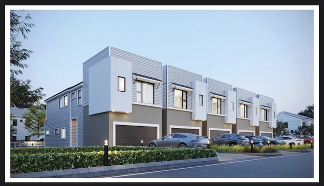 exterior space featuring a garage, stucco siding, and a residential view