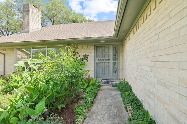 1823 Mandrill Ln, Houston, TX 77067 - property entrance featuring brick siding, roof with shingles, and a chimney