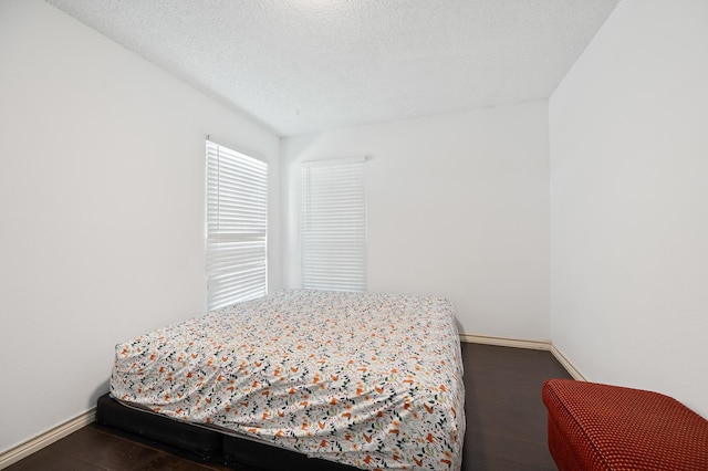 1823 Mandrill Ln, Houston, TX 77067 - bedroom featuring baseboards, a textured ceiling, and dark wood-style flooring