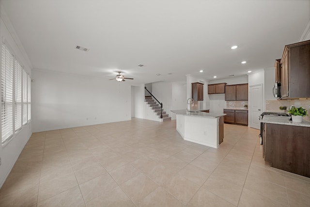 1706 Country Air Ln, Missouri City, TX 77459 - kitchen featuring a ceiling fan, a sink, light stone countertops, decorative backsplash, and open floor plan