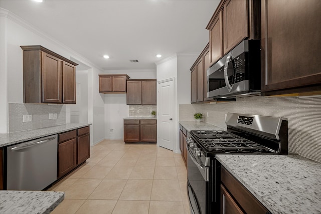 1706 Country Air Ln, Missouri City, TX 77459 - kitchen with light stone counters, crown molding, stainless steel appliances, backsplash, and visible vents