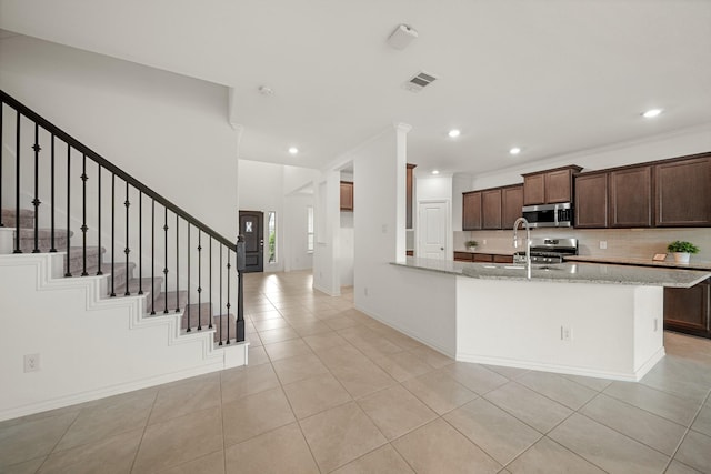 1706 Country Air Ln, Missouri City, TX 77459 - kitchen with light stone counters, light tile patterned floors, stainless steel microwave, visible vents, and recessed lighting