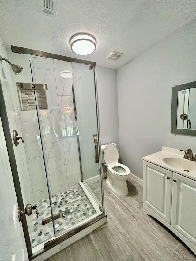 full bathroom with a stall shower, wood finished floors, visible vents, and toilet