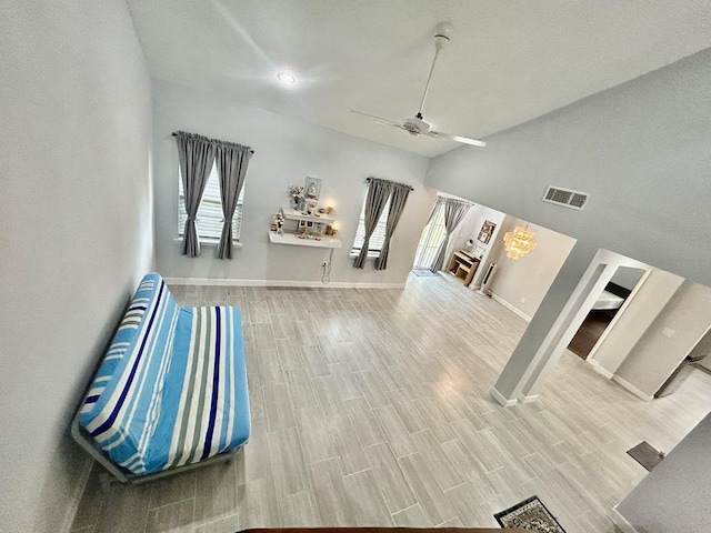 interior space with visible vents, wood finished floors, baseboards, and ceiling fan