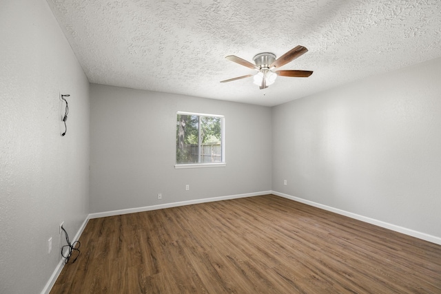 spare room featuring baseboards, wood finished floors, a textured ceiling, and ceiling fan
