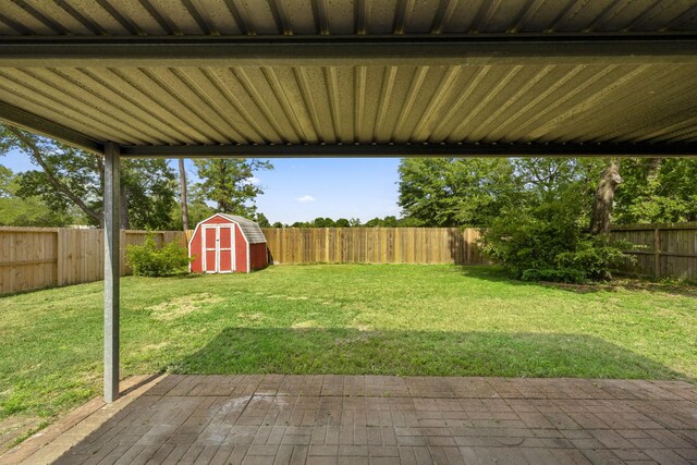 view of yard featuring a patio, a fenced backyard, an outdoor structure, and a shed