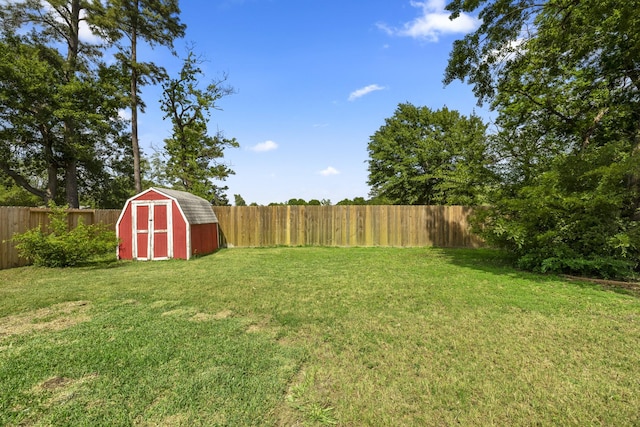 view of yard with a fenced backyard, an outbuilding, and a shed