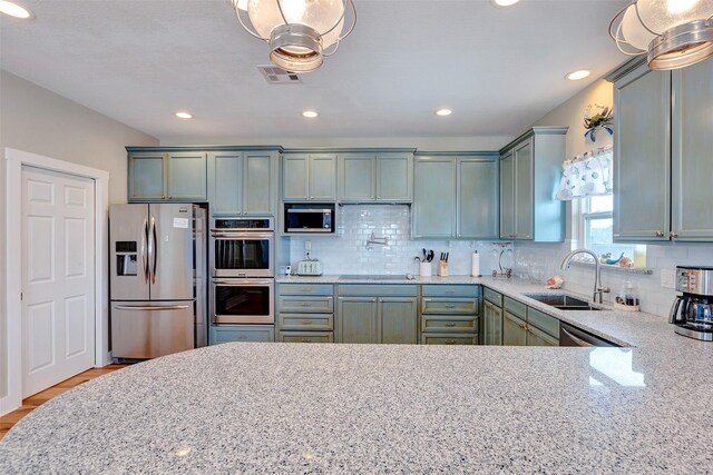 126 Driftwood, Freeport, TX 77541 - kitchen with appliances with stainless steel finishes, a sink, decorative backsplash, light stone counters, and recessed lighting