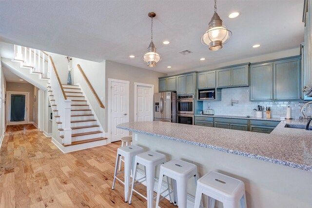 126 Driftwood, Freeport, TX 77541 - kitchen featuring stainless steel appliances, a peninsula, a sink, light stone countertops, and tasteful backsplash