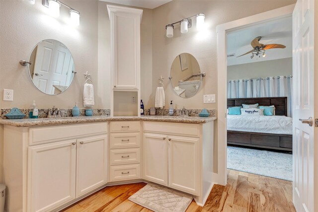 126 Driftwood, Freeport, TX 77541 - bathroom featuring a ceiling fan, wood finished floors, connected bathroom, and double vanity