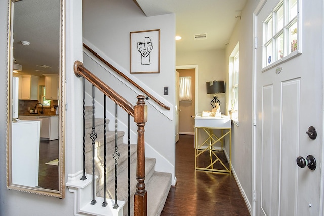 entrance foyer featuring baseboards, wood finished floors, visible vents, and stairs
