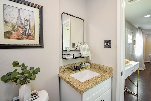 bathroom with recessed lighting, wood finished floors, toilet, and vanity