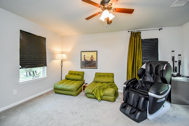 living area with carpet flooring, visible vents, a ceiling fan, and baseboards