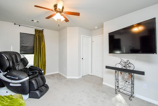 living area featuring carpet floors, visible vents, baseboards, and ceiling fan