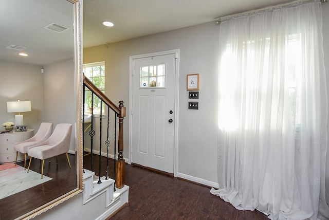entrance foyer featuring baseboards, wood finished floors, stairs, and visible vents