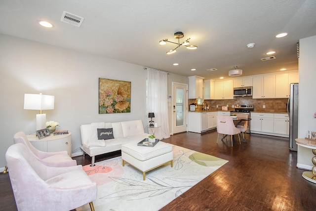 living area featuring an inviting chandelier, dark wood-style flooring, visible vents, and recessed lighting