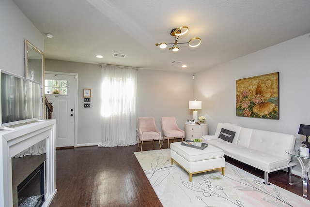 living room featuring wood finished floors, visible vents, recessed lighting, and a high end fireplace