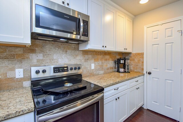 kitchen featuring tasteful backsplash, appliances with stainless steel finishes, and white cabinetry