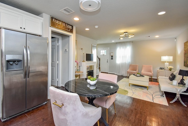 dining room with a tile fireplace, baseboards, dark wood-type flooring, visible vents, and recessed lighting