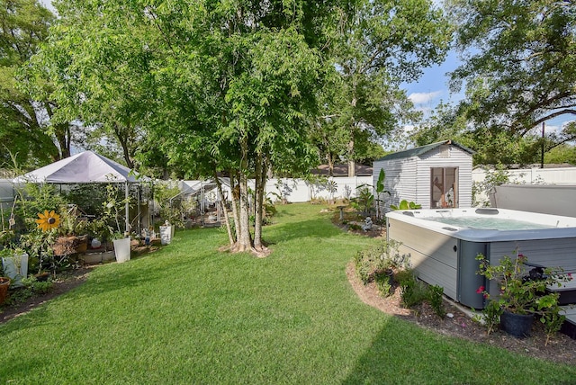 view of yard featuring an outdoor structure, a storage unit, a hot tub, and a fenced backyard