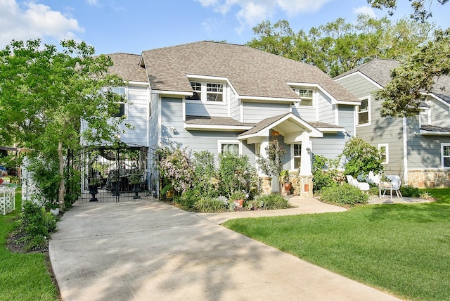 view of front of property with a gate, roof with shingles, and a front lawn