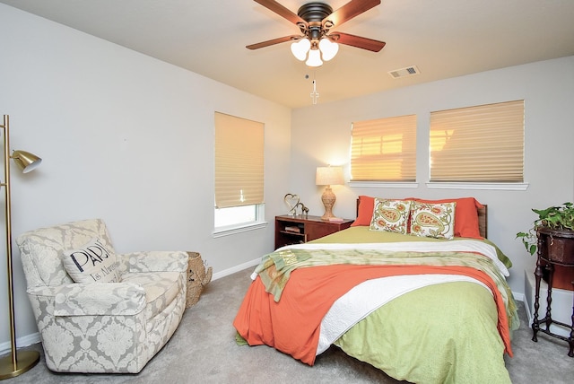 carpeted bedroom featuring baseboards, a ceiling fan, and visible vents