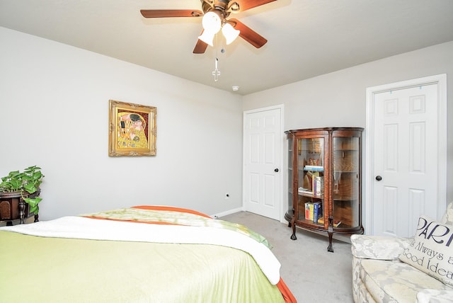 bedroom with ceiling fan, light carpet, and baseboards