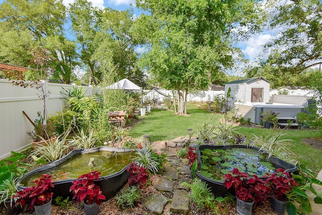 view of yard featuring a fenced backyard, an outbuilding, and a storage shed