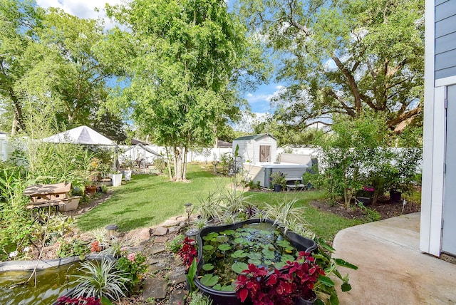 view of yard featuring an outdoor structure, a shed, and a fenced backyard