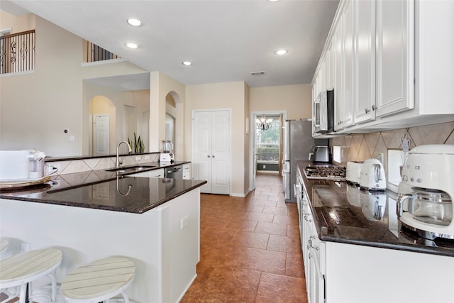7410 Norwood Point Ct, Richmond, TX 77407 - kitchen with a sink, tasteful backsplash, recessed lighting, arched walkways, and a kitchen breakfast bar