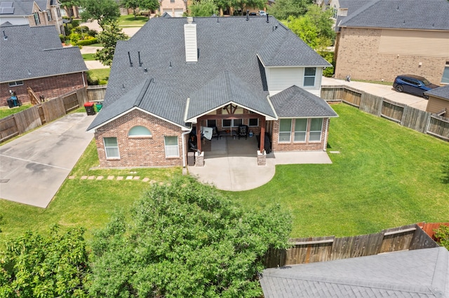 7410 Norwood Point Ct, Richmond, TX 77407 - rear view of property featuring brick siding, a shingled roof, a chimney, a patio, and a residential view