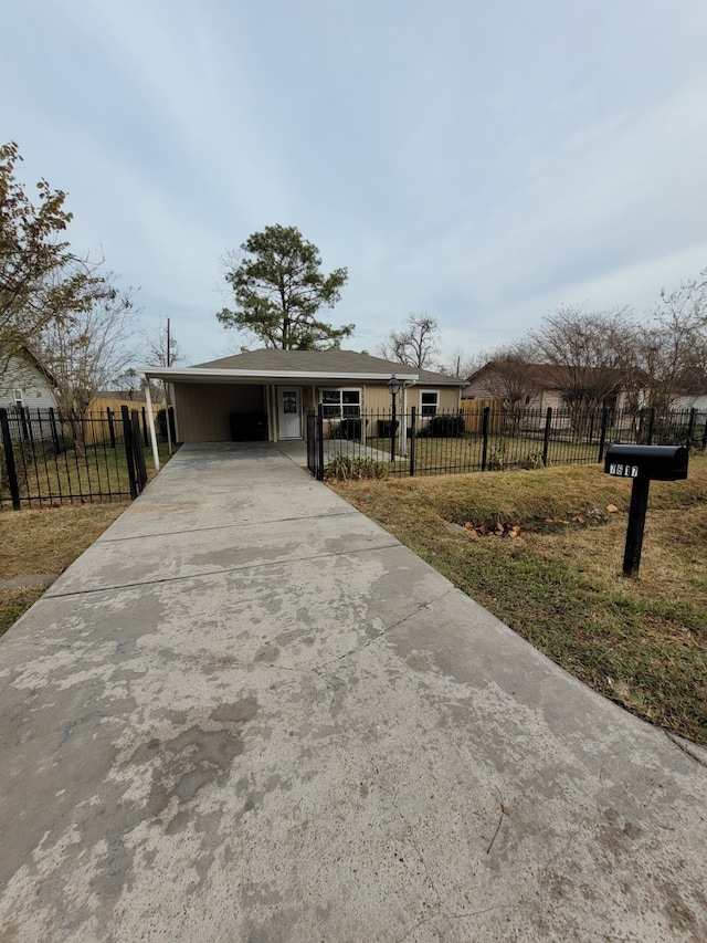 ranch-style house featuring a front lawn, a fenced front yard, and concrete driveway