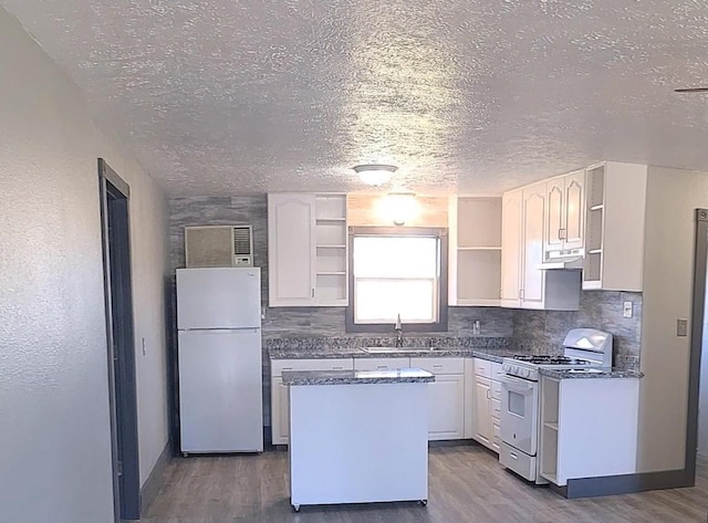 kitchen featuring dark wood finished floors, open shelves, a textured ceiling, and white appliances