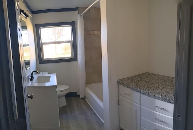 bathroom with wood finished floors, shower / bath combo with shower curtain, toilet, and vanity