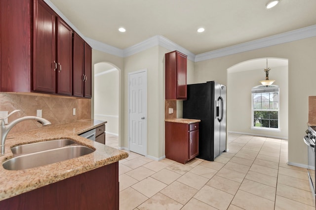 2830 Meadowbrook Ln, Rosenberg, TX 77471 - kitchen with reddish brown cabinets, a sink, arched walkways, black fridge with ice dispenser, and decorative backsplash