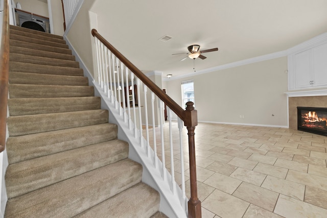 2830 Meadowbrook Ln, Rosenberg, TX 77471 - stairs featuring visible vents, a ceiling fan, crown molding, baseboards, and a glass covered fireplace