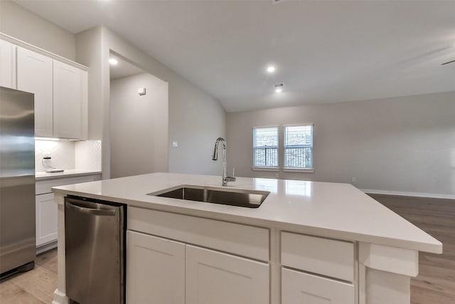 kitchen with light wood-type flooring, a sink, light countertops, and stainless steel appliances