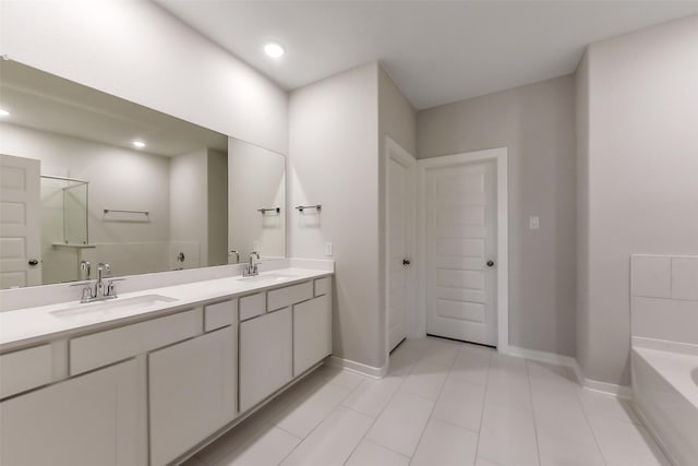 bathroom with double vanity, baseboards, a sink, and tile patterned flooring