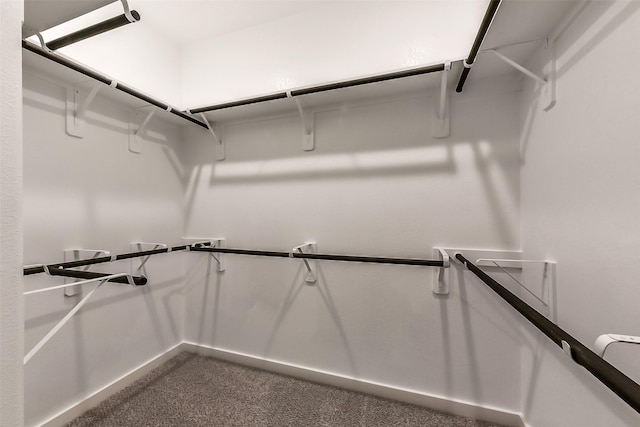 spacious closet with dark carpet