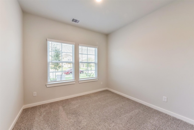 empty room featuring visible vents, carpet, and baseboards