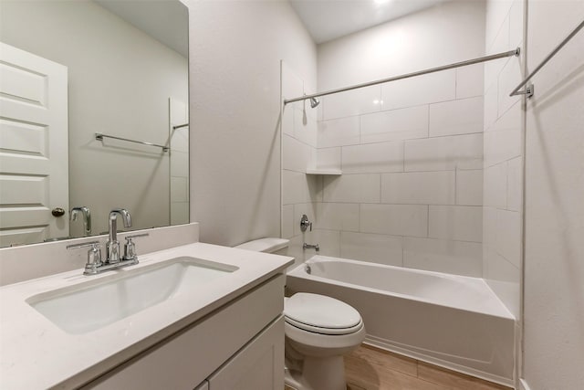 bathroom featuring wood finished floors, bathtub / shower combination, toilet, and vanity