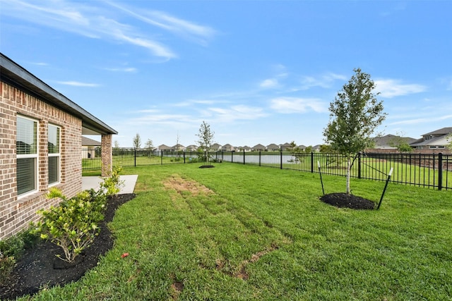 view of yard featuring a residential view, a fenced backyard, and a patio area