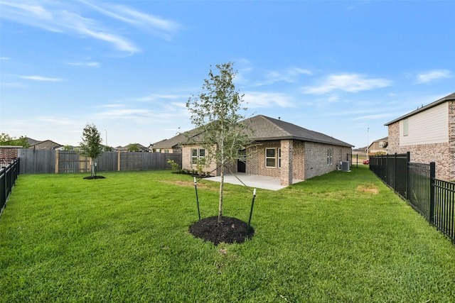 view of yard featuring a fenced backyard, a patio, and central AC