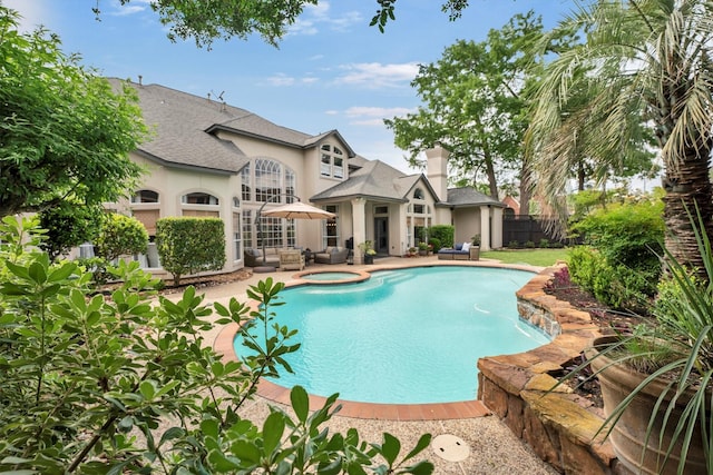 view of pool featuring outdoor lounge area, a patio, a pool with connected hot tub, and fence