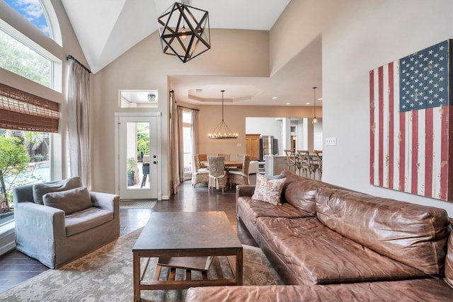living room with a chandelier, high vaulted ceiling, and wood finished floors