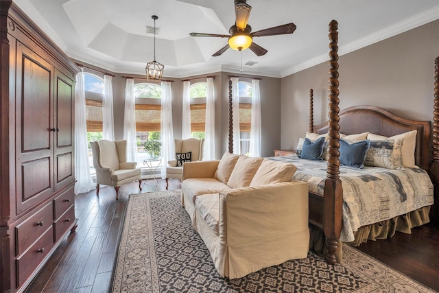 bedroom featuring visible vents, dark wood-style flooring, crown molding, and a tray ceiling