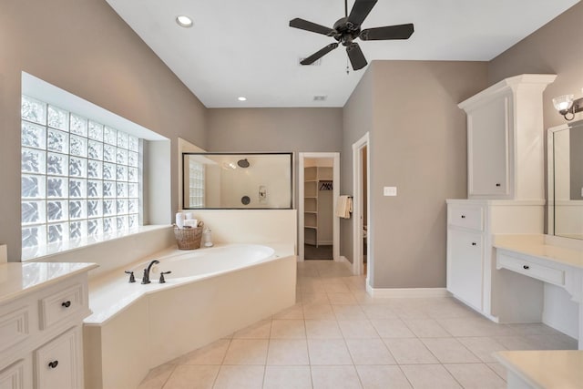 full bath with a shower stall, tile patterned floors, a ceiling fan, a garden tub, and a spacious closet