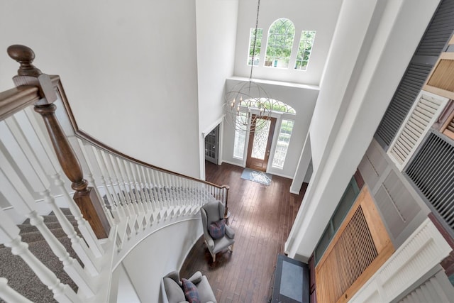 entrance foyer featuring stairway, a towering ceiling, plenty of natural light, and a notable chandelier