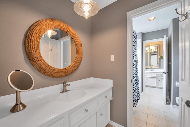 bathroom with vanity, a notable chandelier, tile patterned floors, and baseboards