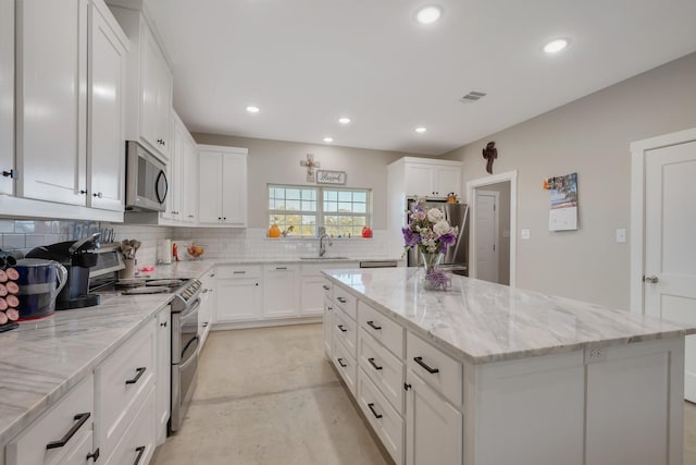 414 N Old Springfield Rd, North Zulch, TX 77872 - kitchen with stainless steel appliances, a center island, a sink, recessed lighting, and backsplash